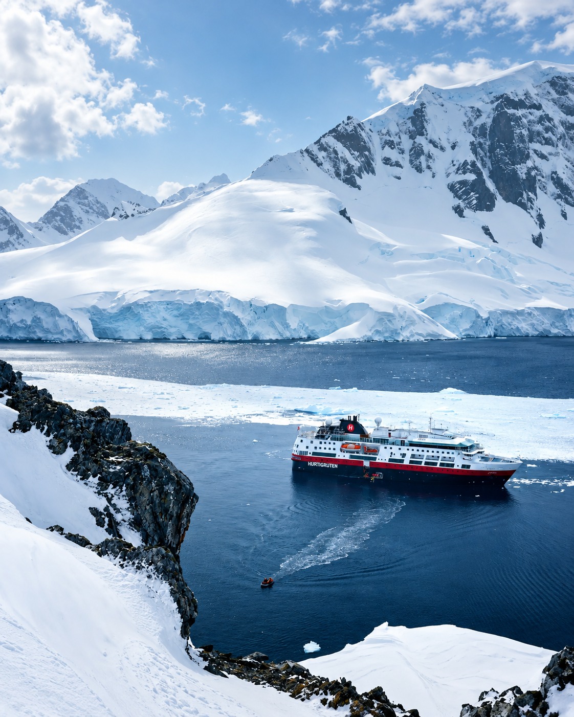 Navio de expedição navegando entre geleiras e montanhas nevadas